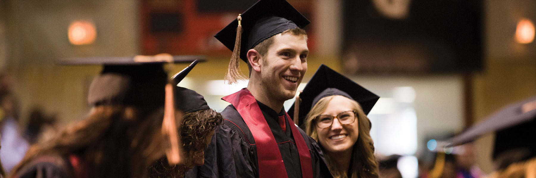 Young man smiling and celebrating his graduation during commencement.