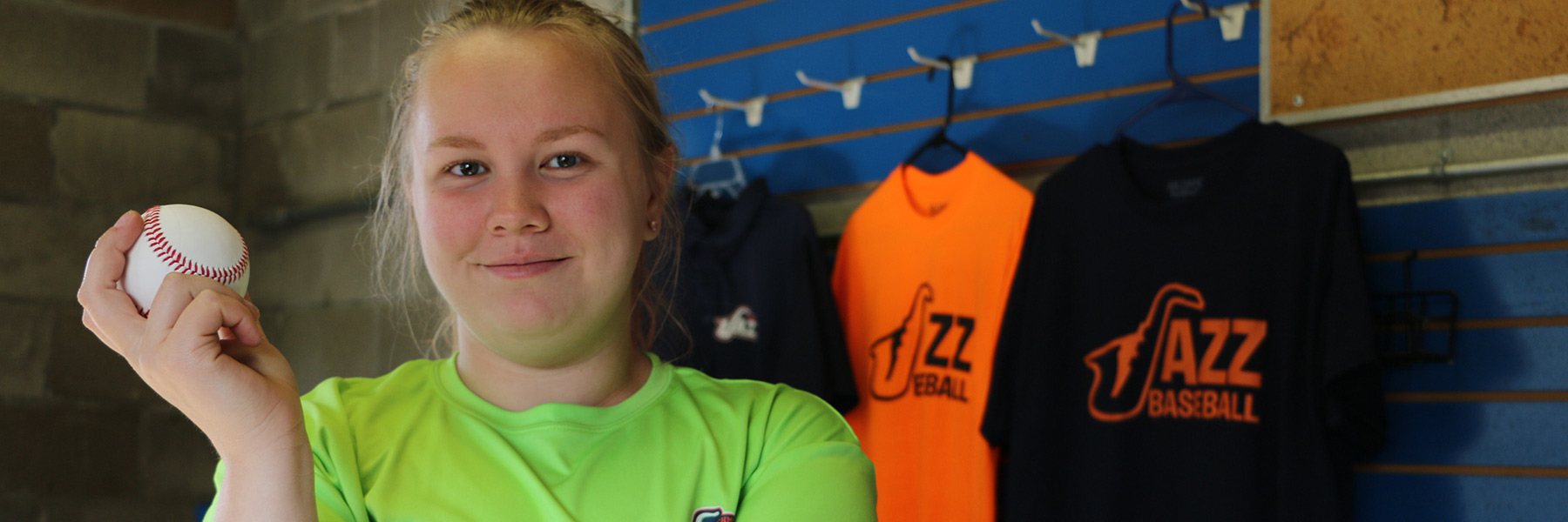 Tiani Christian smiling and holding a baseball during her internship.